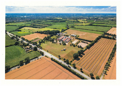 Eine Luftbildaufnahme zeigt Wiesen, Straßen und einen Reitstall